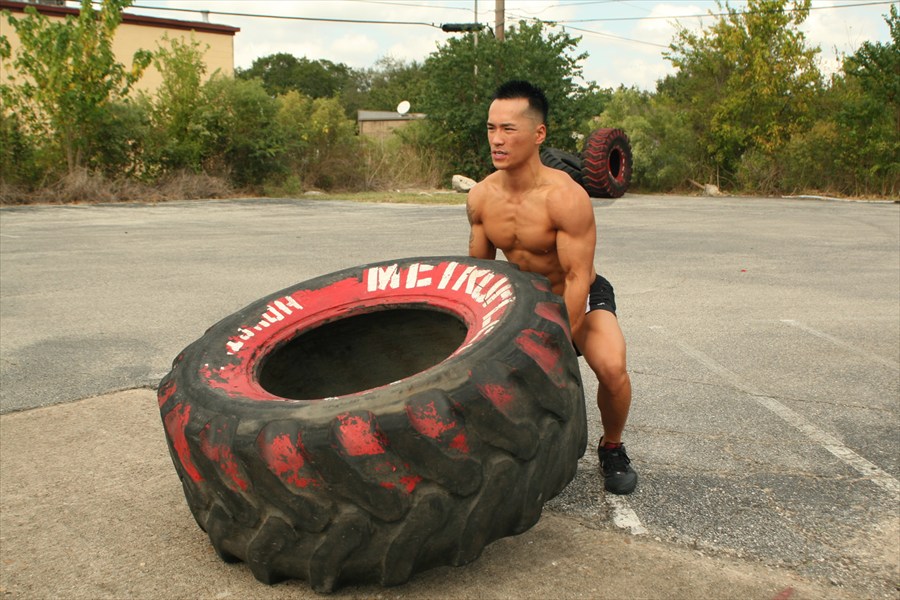 Trainer lifting big tire pose...
