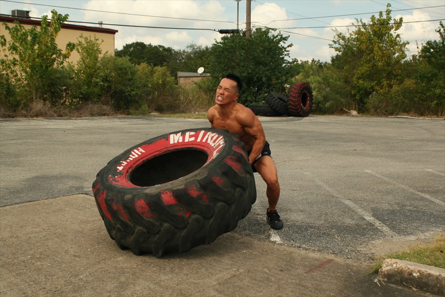 Trainer flipping big tire exercise