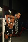 Trainer performing shoulder dips with chains